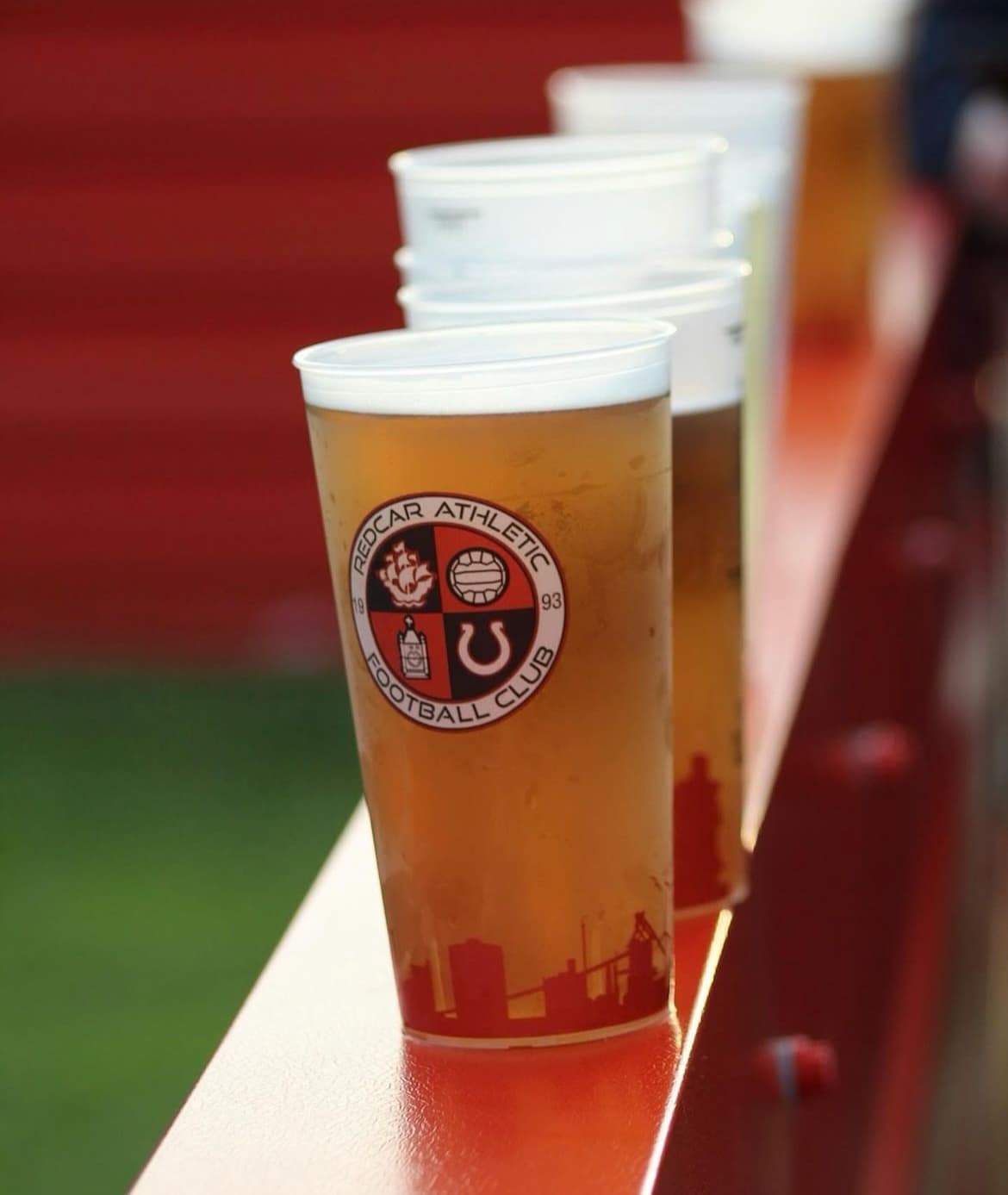 Bar staff serving beer in reusable plastic cups
